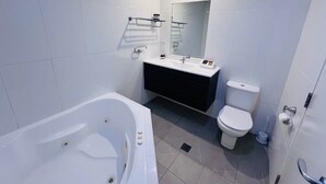 Ein modernes Badezimmer mit Badewanne, Toilette und Waschtisch.