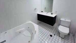 Une salle de bain moderne avec une baignoire blanche, un lavabo et des toilettes.