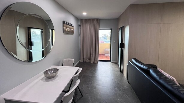 Une cuisine moderne avec une table à manger, des chaises, un grand miroir et un banc intégré.