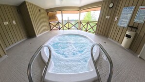 A hot tub with a wooden deck and a view of trees. - 2BR 2BA Village Escape w/ Updated Hot Tub, Perfect Location & Mountain Views (Whistler)