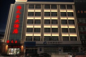 Un edificio de varios pisos con un letrero llamativo en la fachada.