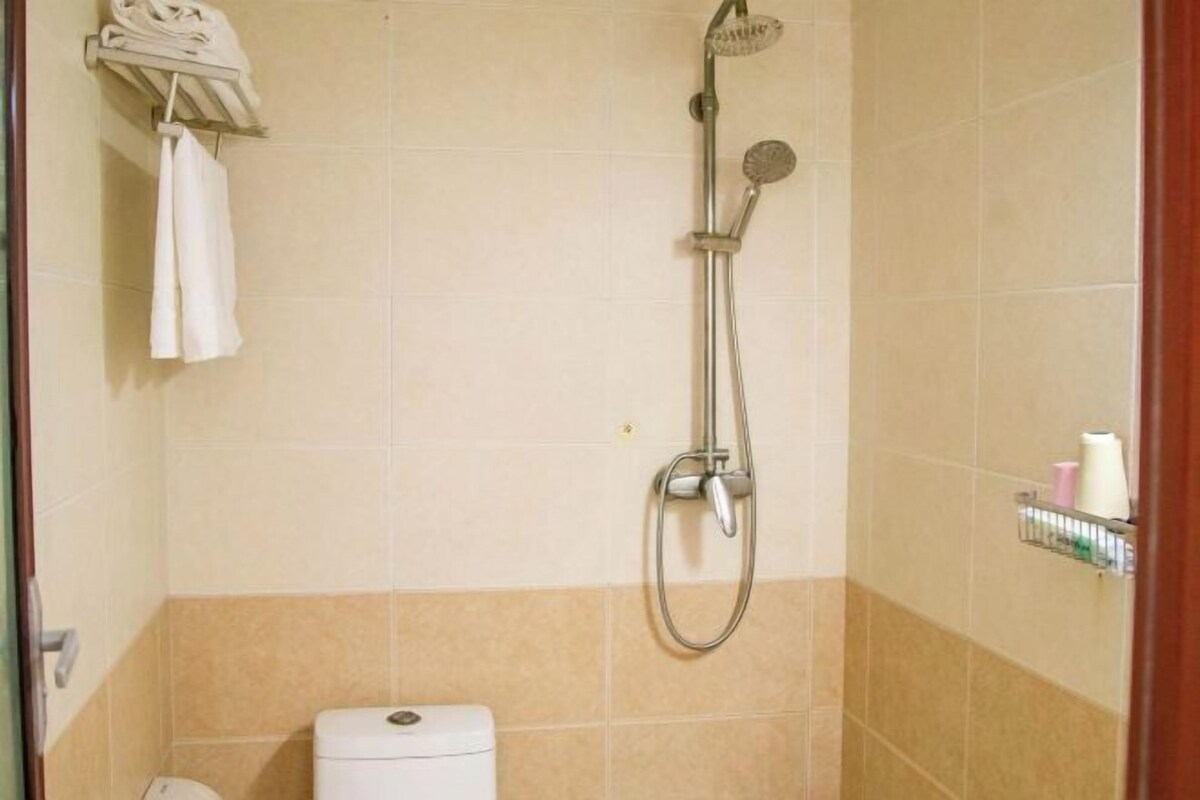 Un bagno con doccia, wc e portasciugamani.