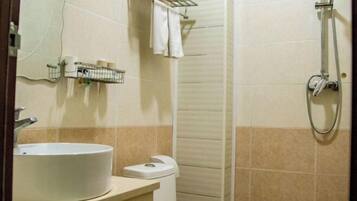 Un baño con lavamanos, inodoro y ducha.