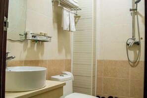 Un bagno con lavandino, WC e doccia.