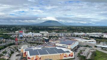 A large commercial building with solar panels, a Ferris wheel, and a mountain in the background.