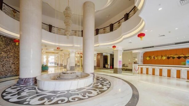 A spacious lobby with a central fountain, marble flooring, and a reception area with a modern design. - Shishi Laiya Fortune Hotel (Quanzhou South Railway Station) (Shishi)