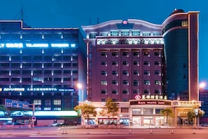 A multi-story hotel with a prominent 'Raya wealth hotel' sign, featuring a modern facade with large windows and a curved corner design. - Shishi Laiya Fortune Hotel (Quanzhou South Railway Station) (Shishi)