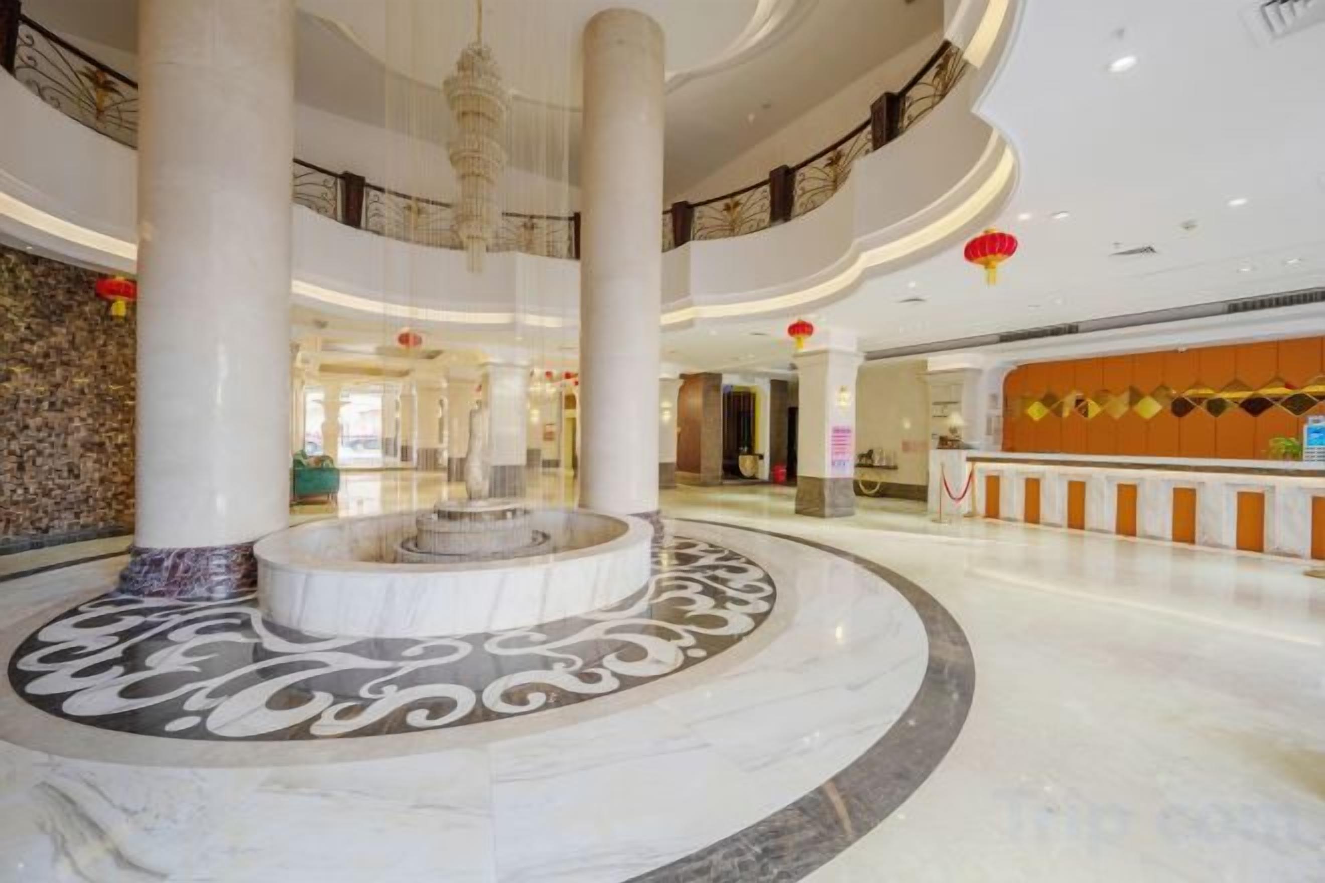 A spacious lobby with a central fountain, multiple floors, and a reception desk.