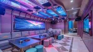 A modern lounge area with a checkered floor, seating arrangements, and a large screen displaying a dynamic light show. - Shishi Laiya Fortune Hotel (Quanzhou South Railway Station) (Shishi)