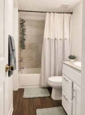Une salle de bain avec une baignoire, des toilettes et un meuble-lavabo.