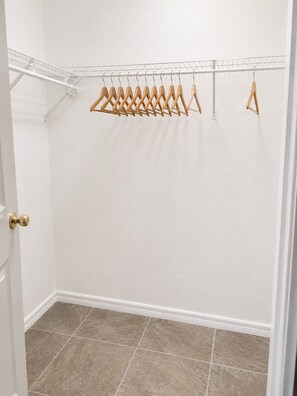 Un armadio con una porta bianca, un soffitto bianco e un pavimento piastrellato.