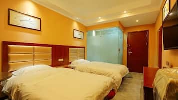 A hotel room with two beds, a wooden headboard, a wardrobe, a television, and a framed certificate on the wall.