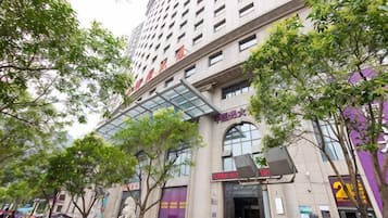 A multi-story hotel with a glass entrance and signage indicating amenities.