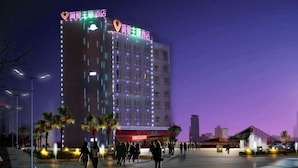 A hotel with multiple floors, illuminated windows, and a prominent sign with heart symbols. - Yueqing Jane Eyre Theme Hotel (Yueqing)