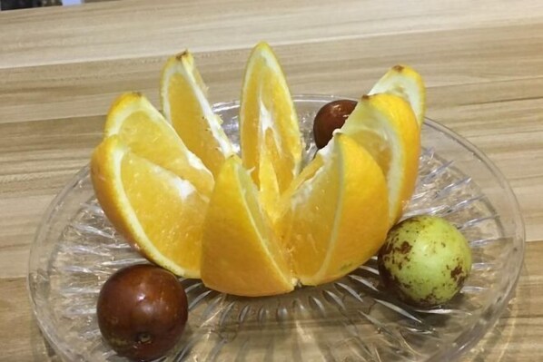 A glass plate with sliced oranges and a few other fruits. - Yueqing Jane Eyre Theme Hotel (Yueqing)
