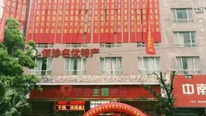 A hotel facade with multiple red banners and a prominent sign for a hotel named "Bai Xian". - Yueqing Jane Eyre Theme Hotel (Yueqing)