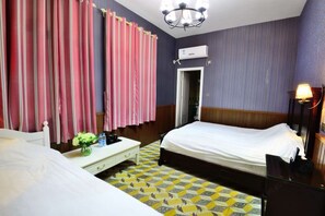 A hotel room with a bed, bedside table, and a desk with a lamp. - Fuxing No. 10 Hotel (Xiamen)