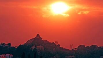 A sunset over a hill with buildings in the foreground.