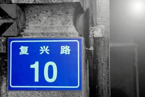 A blue sign with white text on a wall, indicating a location or route number. - Fuxing No. 10 Hotel (Xiamen)