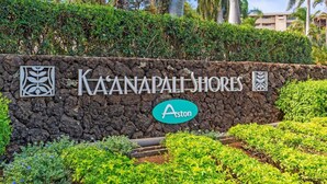 A sign for Kaanapali Shores with a logo and the word "Aston" on a stone wall. - Spacious 2 Bed with Views! (Lahaina)