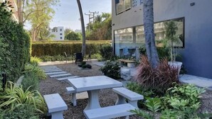 A modern outdoor patio with a stone pathway, seating area, and greenery. - Stardust Boutique Hotel (Hua Hin)