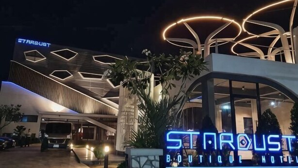 A modern hotel with a distinctive geometric facade and illuminated signage. - Stardust Boutique Hotel (Hua Hin)