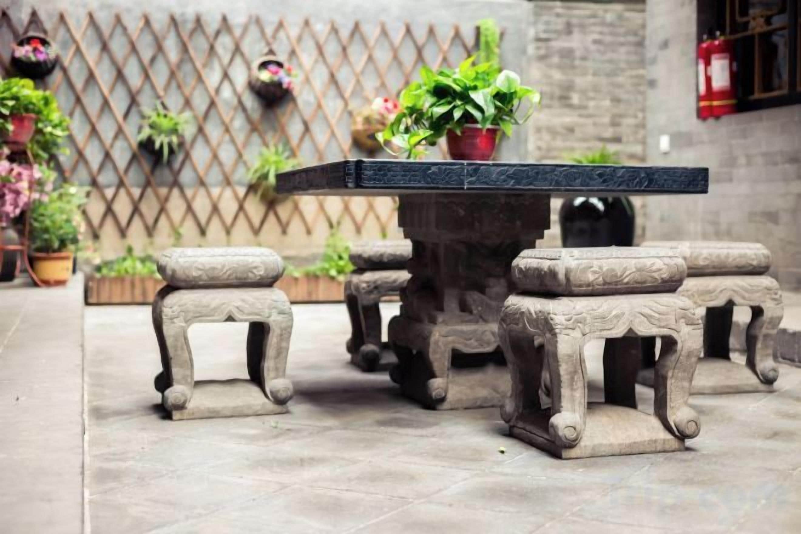 A stone table with matching stools in a courtyard.