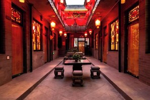 A corridor with traditional Chinese architecture, featuring wooden doors, lanterns, and tiled flooring. - Pingyao Longyuan Inn (Pingyao County)