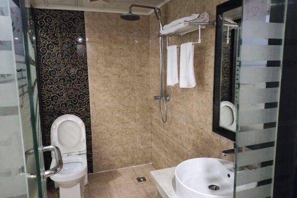 A modern bathroom with a glass-enclosed shower, a toilet, and a sink. - Jiuyuejiu Business Hotel (Tongxiang)