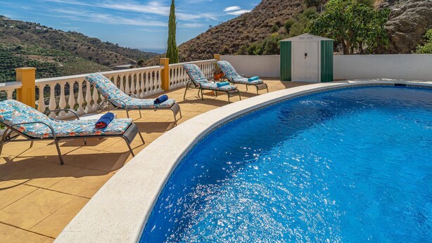 A swimming pool with lounge chairs and a view of a hilly landscape. - Cozy home in Sayalonga with WiFi (Sayalonga)