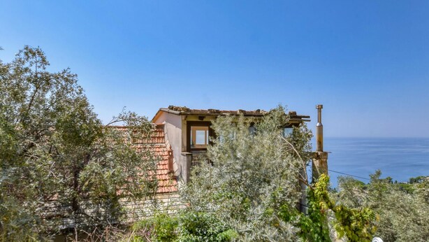 A rustic building with a tiled roof, surrounded by dense vegetation, overlooking a body of water. - 1 bedroom lovely home in Pieve Ligure (Pieve Ligure)