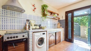 A compact kitchen with a gas stove, washing machine, and tiled backsplash. - 1 bedroom lovely home in Pieve Ligure (Pieve Ligure)