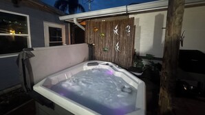 Ein Whirlpool mit Holzzaun und dekorativen Elementen im Hintergrund.