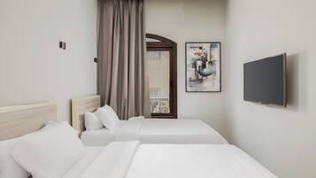 Una habitación de hotel con dos camas, un televisor y un cuadro en la pared.