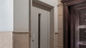 A door with a vertical handle, a textured wall, and a dark wooden door frame. - Sleep Inn Apart-hotel (New Cairo)