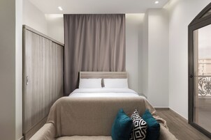 Una camera da letto con un letto, un armadio, una tenda e una vista attraverso una porta.