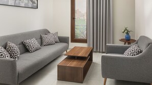 A modern living room with a grey sofa, matching armchair, and a wooden coffee table. - Sleep Inn Apart-hotel (New Cairo)