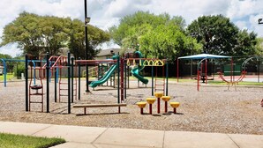 A playground with various play structures including slides and climbing frames. - Katy Hideaway Charming 3 Bdr! (Katy)