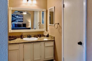 Un bagno con uno specchio grande, un lavandino e una porta.