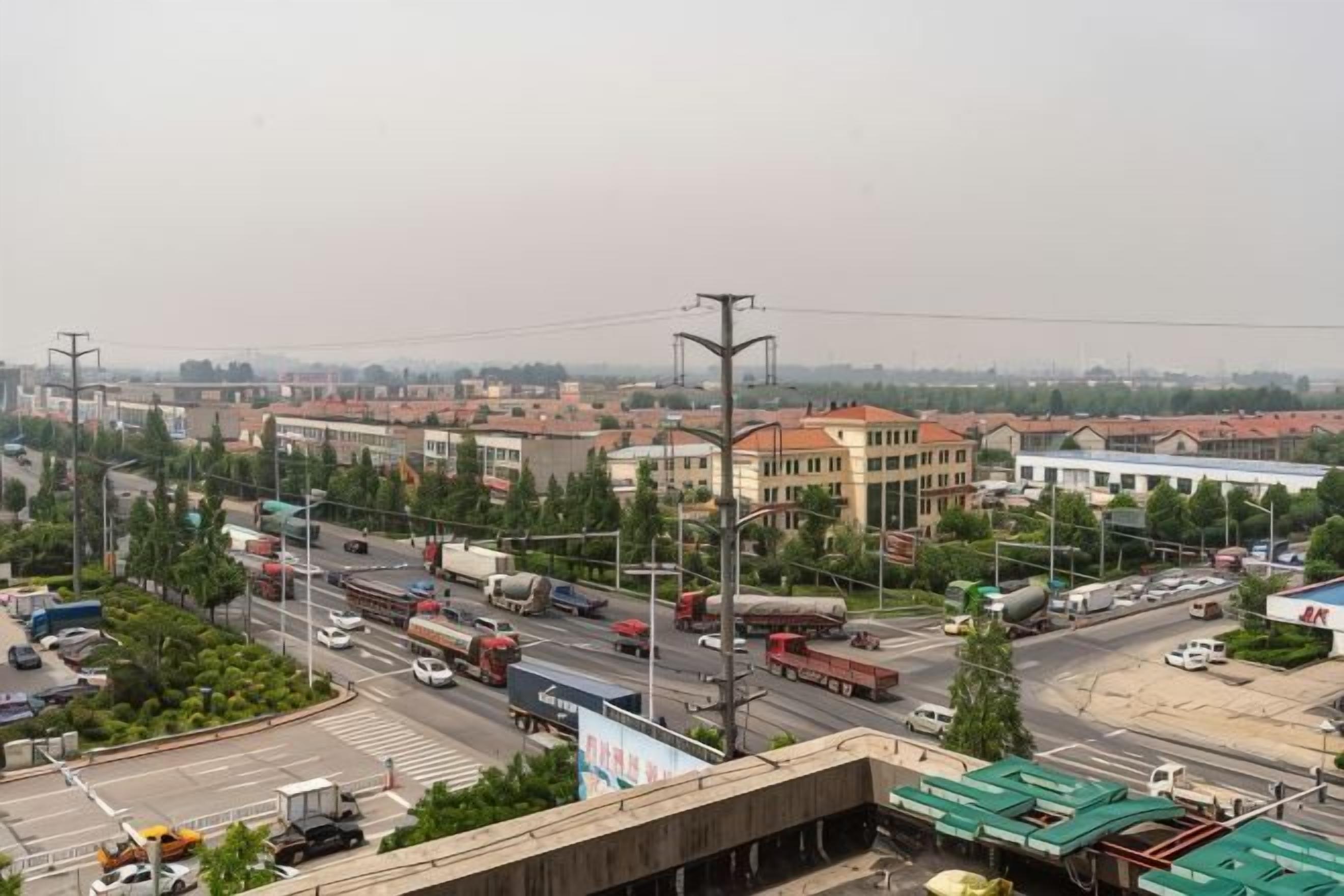 A cityscape with a wide road, buildings, and a clear sky.