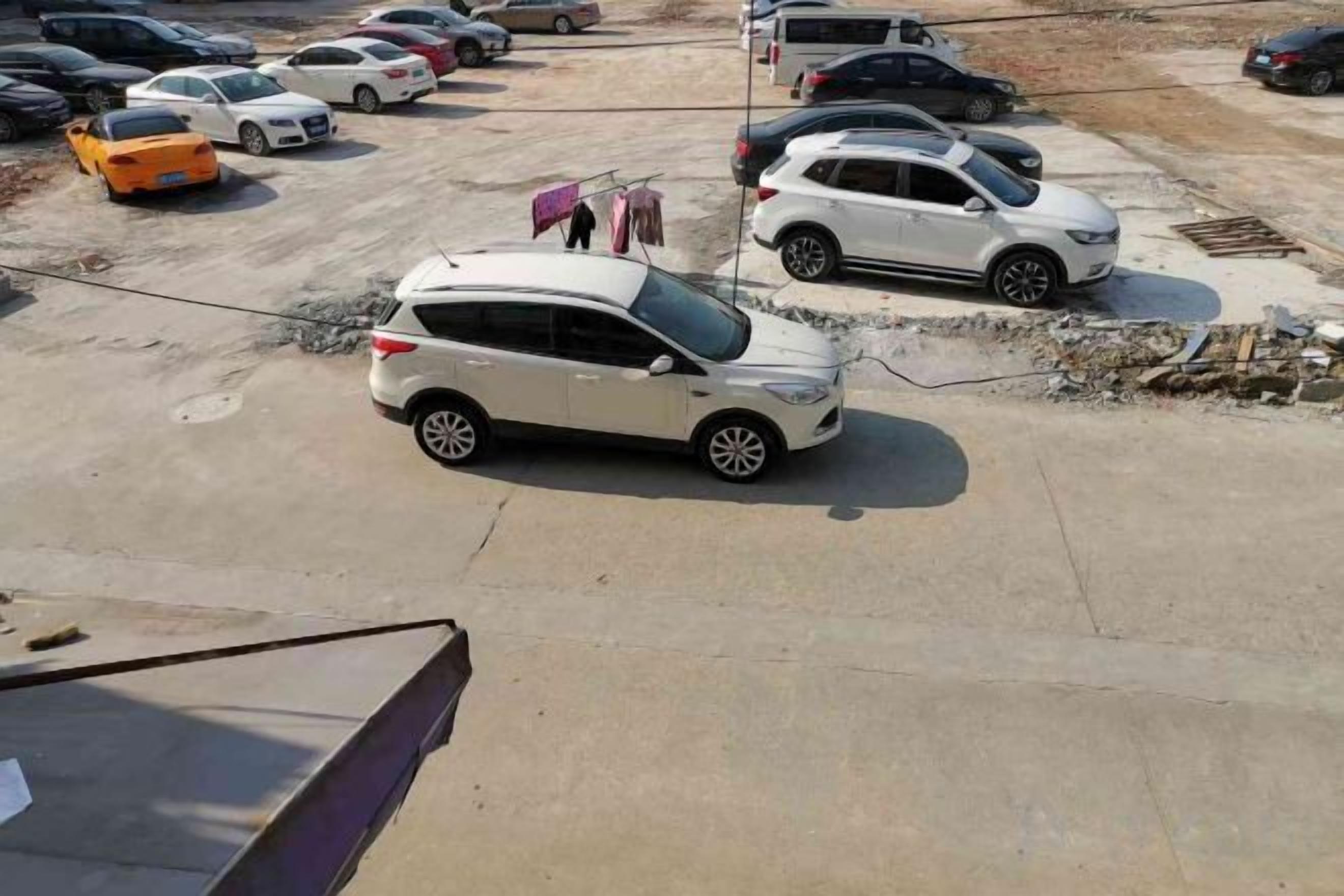 A parking lot with multiple cars, including a white SUV and a silver sedan.