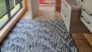 A bedroom with a bed, a window, a door, and a bathroom with a sink and mirror. - Eldeweiss Normand (Saint-Marcel)