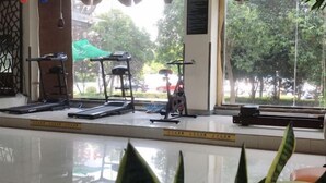 A gym with treadmills, a stationary bike, and a weight bench. - GreenTree Inn (Taizhou Yangzijiang Middle Road) (Taizhou)