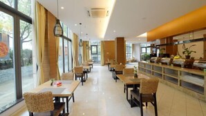 A modern restaurant with a long counter, wicker chairs, and a view of the outdoors. - GreenTree Inn (Taizhou Yangzijiang Middle Road) (Taizhou)