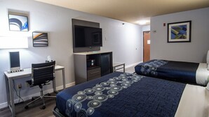Habitació d'hotel amb escriptori, cadira, televisió i dos llits.