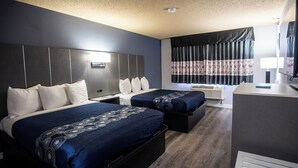 Habitació d'hotel amb dos llits, una taula de treball i una finestra amb cortines.