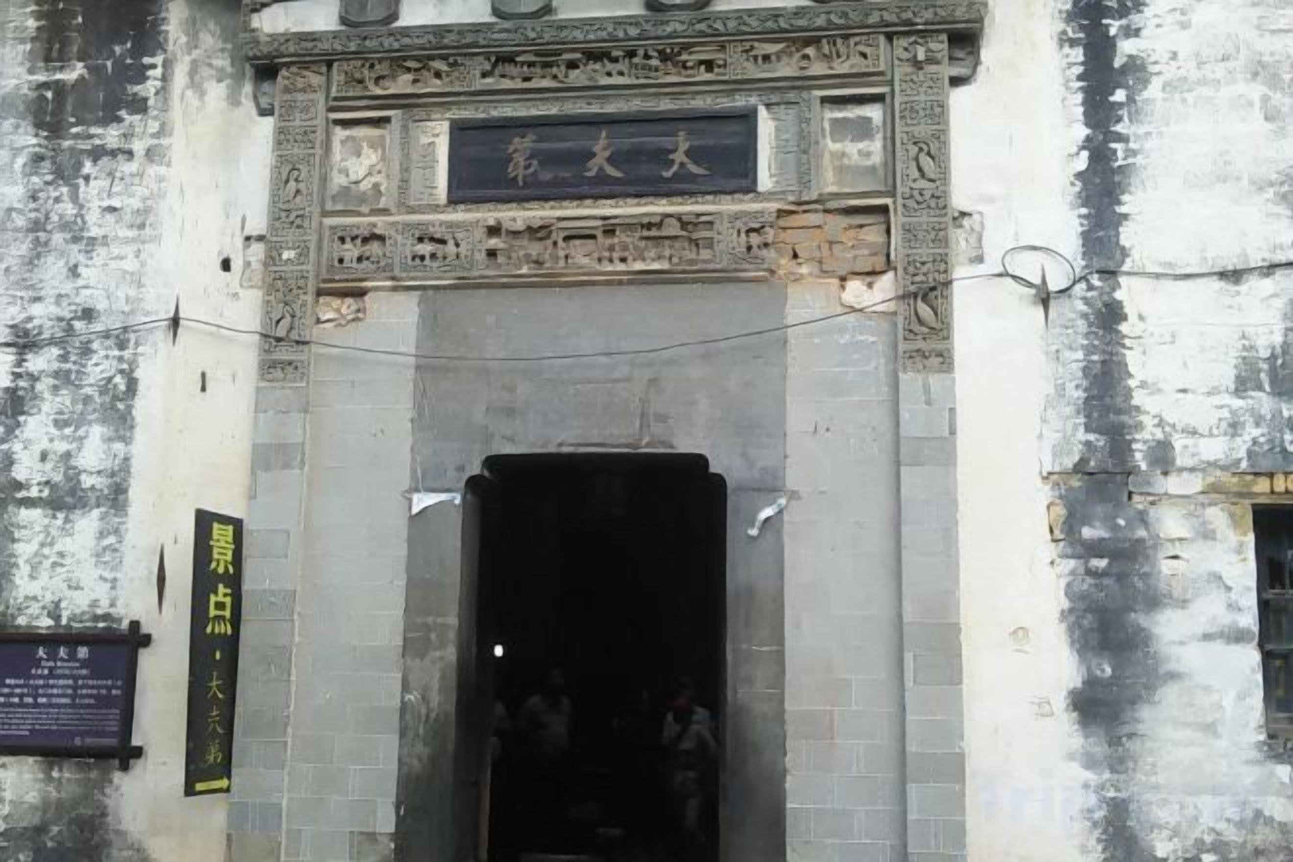 A building entrance with a large archway and a sign above it.