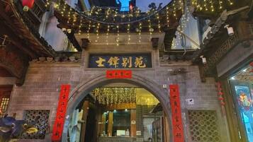 An entrance with traditional Chinese architecture, featuring an arched doorway and decorative lights.
