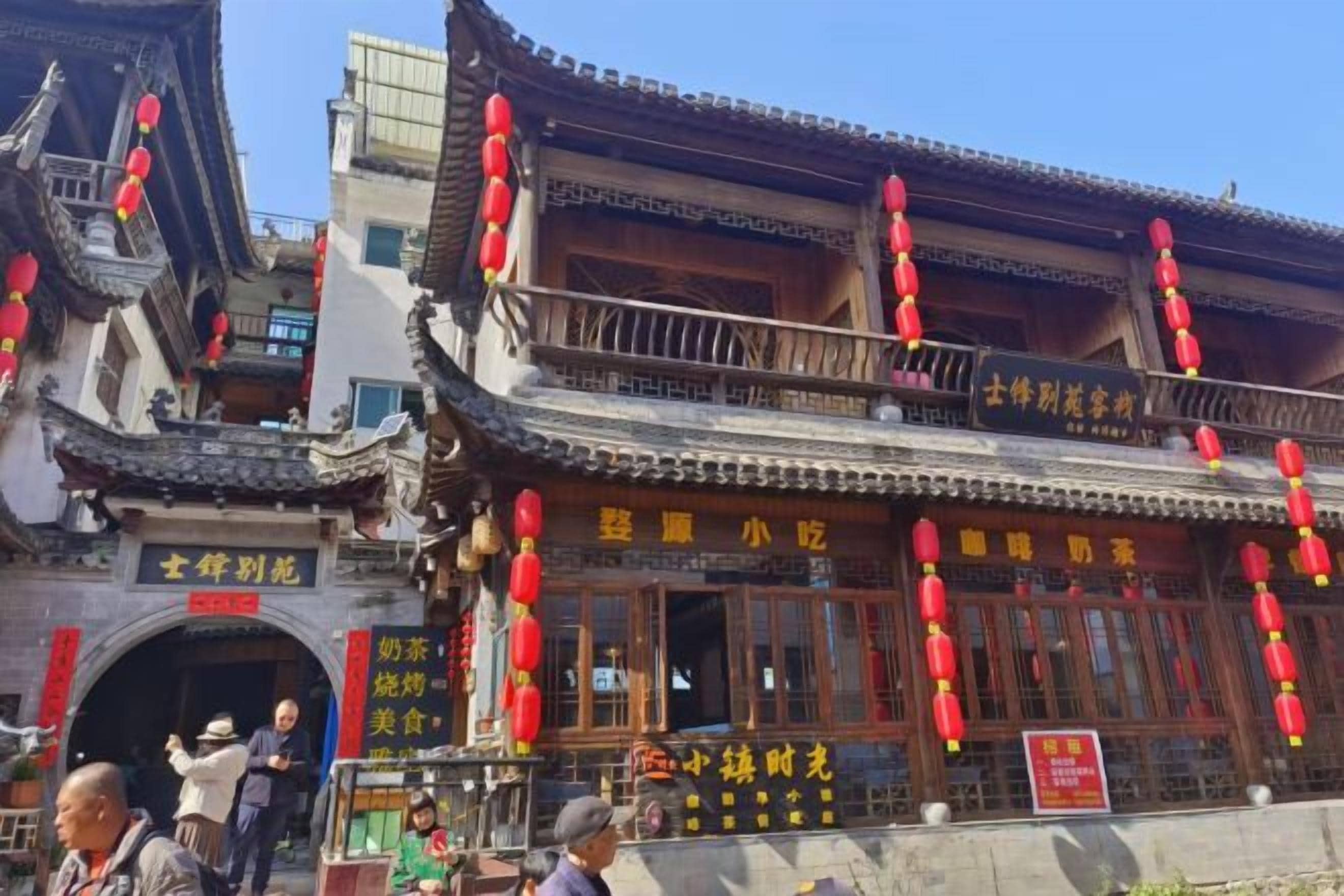 A traditional building with a balcony, red lanterns, and signage indicating a restaurant.
