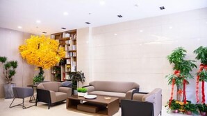 A modern lobby with a beige sofa, a coffee table, and a bookshelf.
